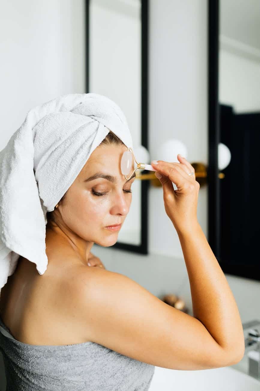 a woman wearing a head towel massaging face