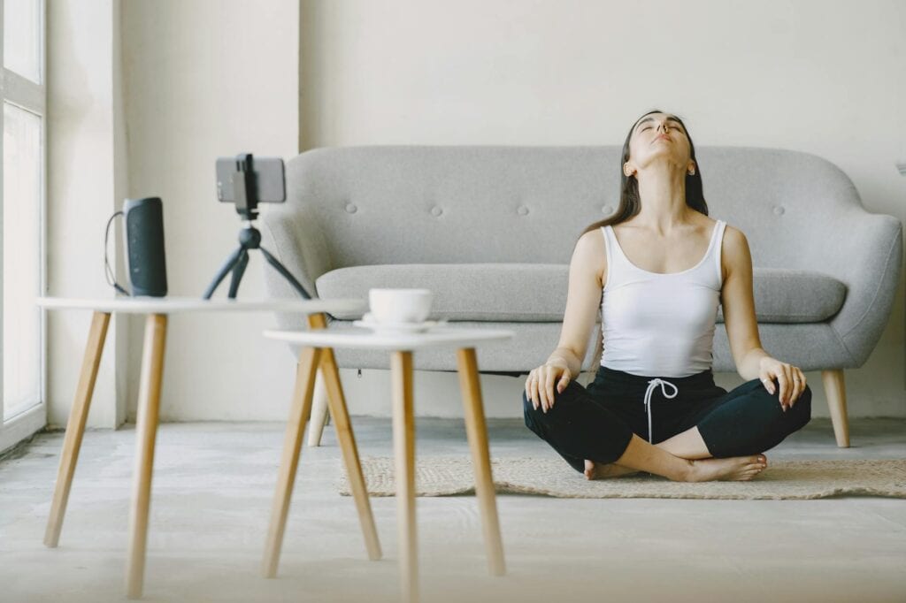 woman sitting on rug meditating