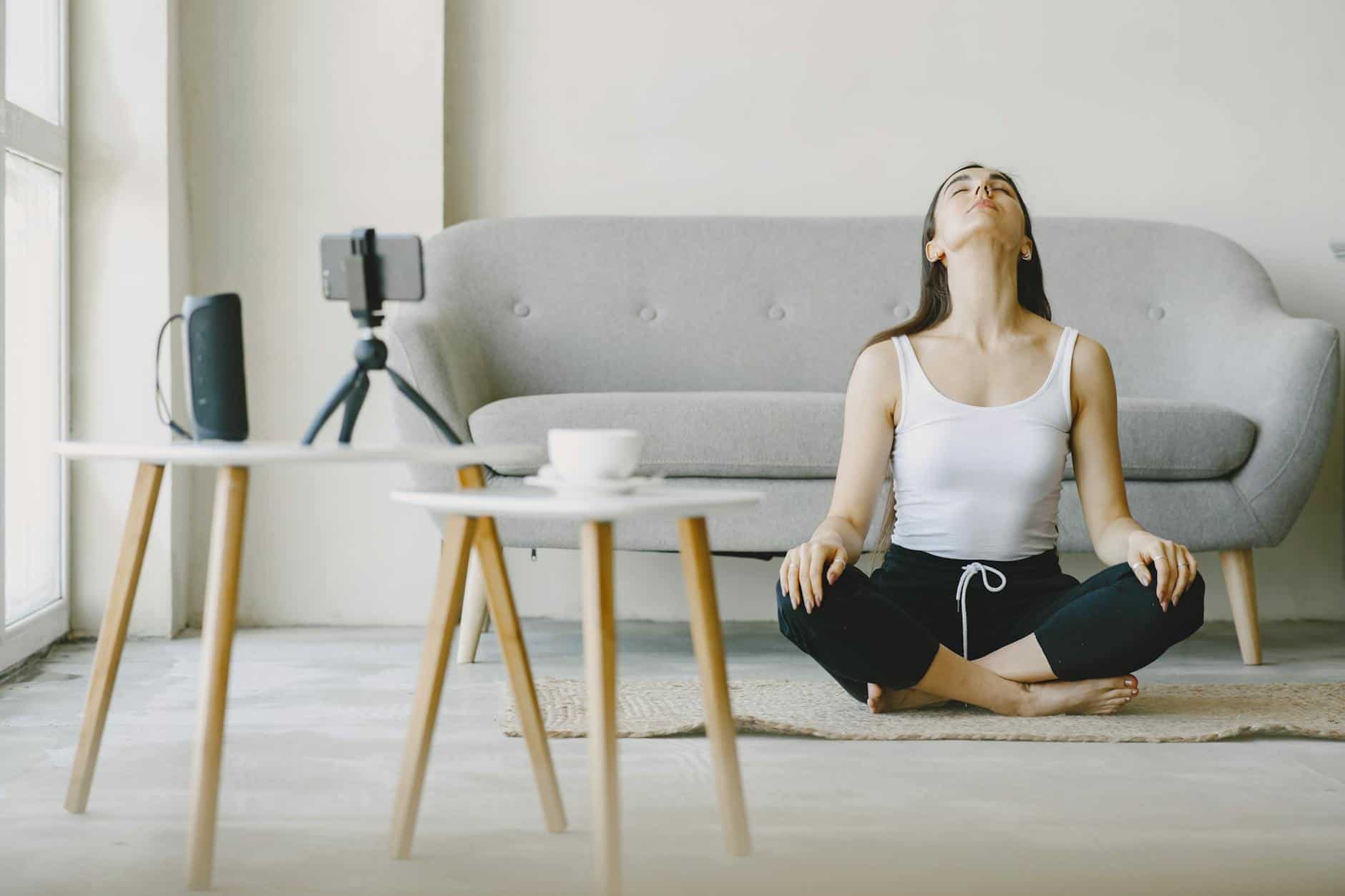 woman sitting on rug meditating