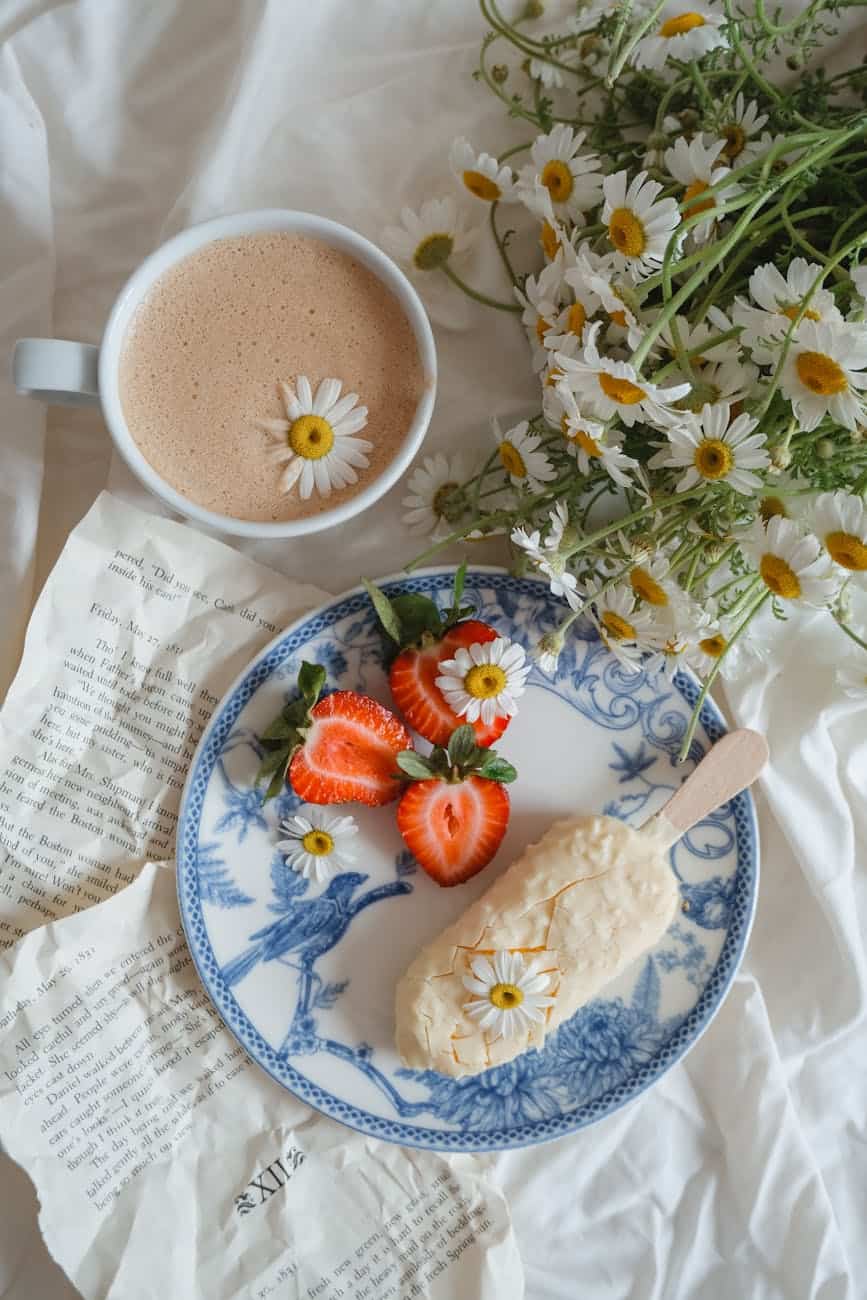 strawberries and ice cream served with coffee on ceramic plate