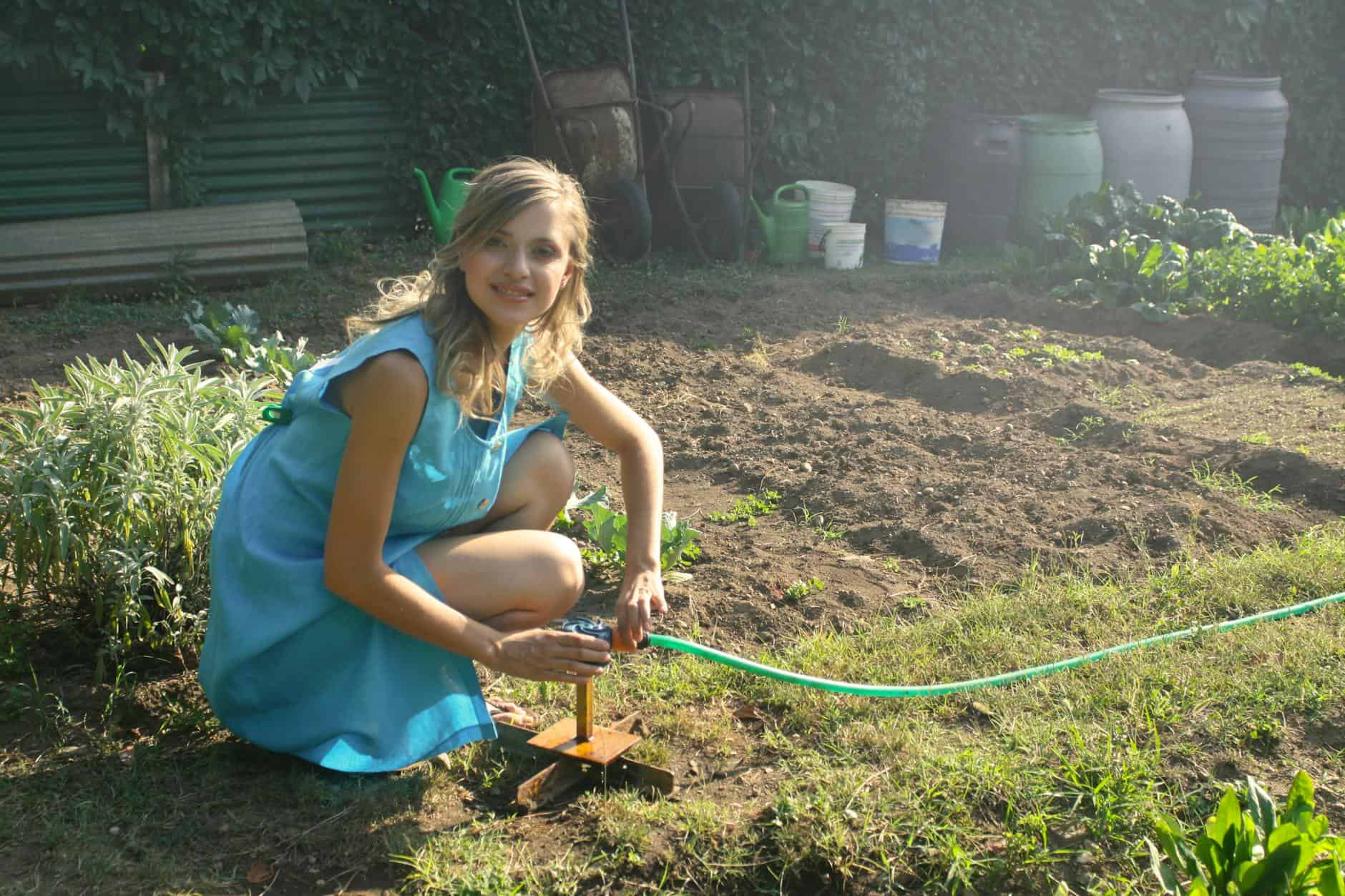 photo woman holding green garden hose