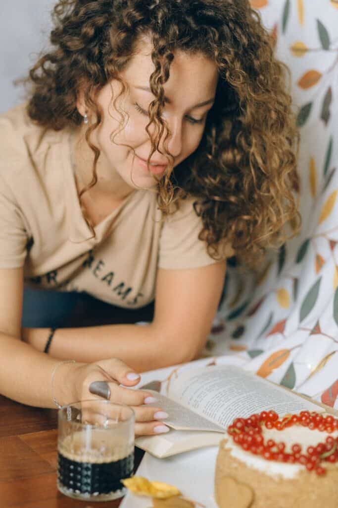 woman in curly hair reading a book