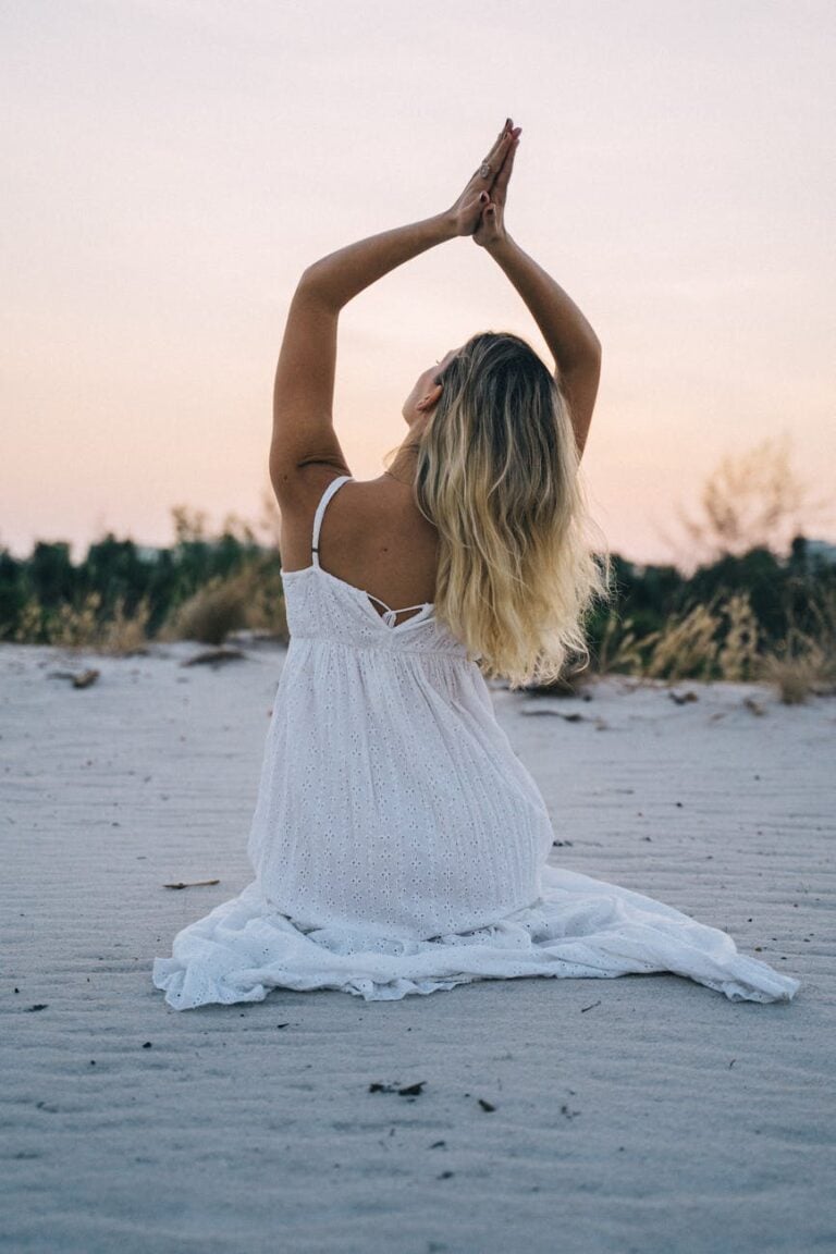 woman in white dress sitting on beach