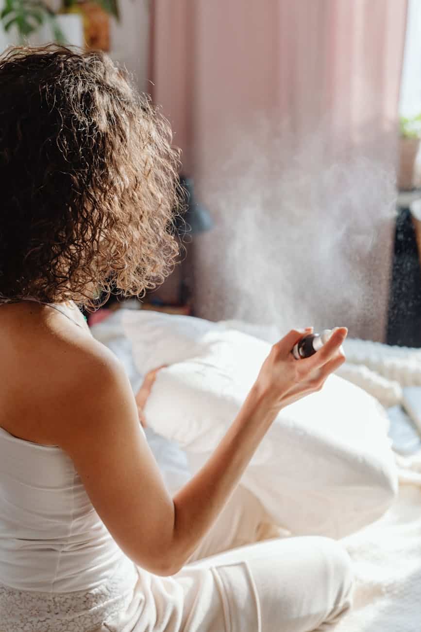 a woman spraying her pillow