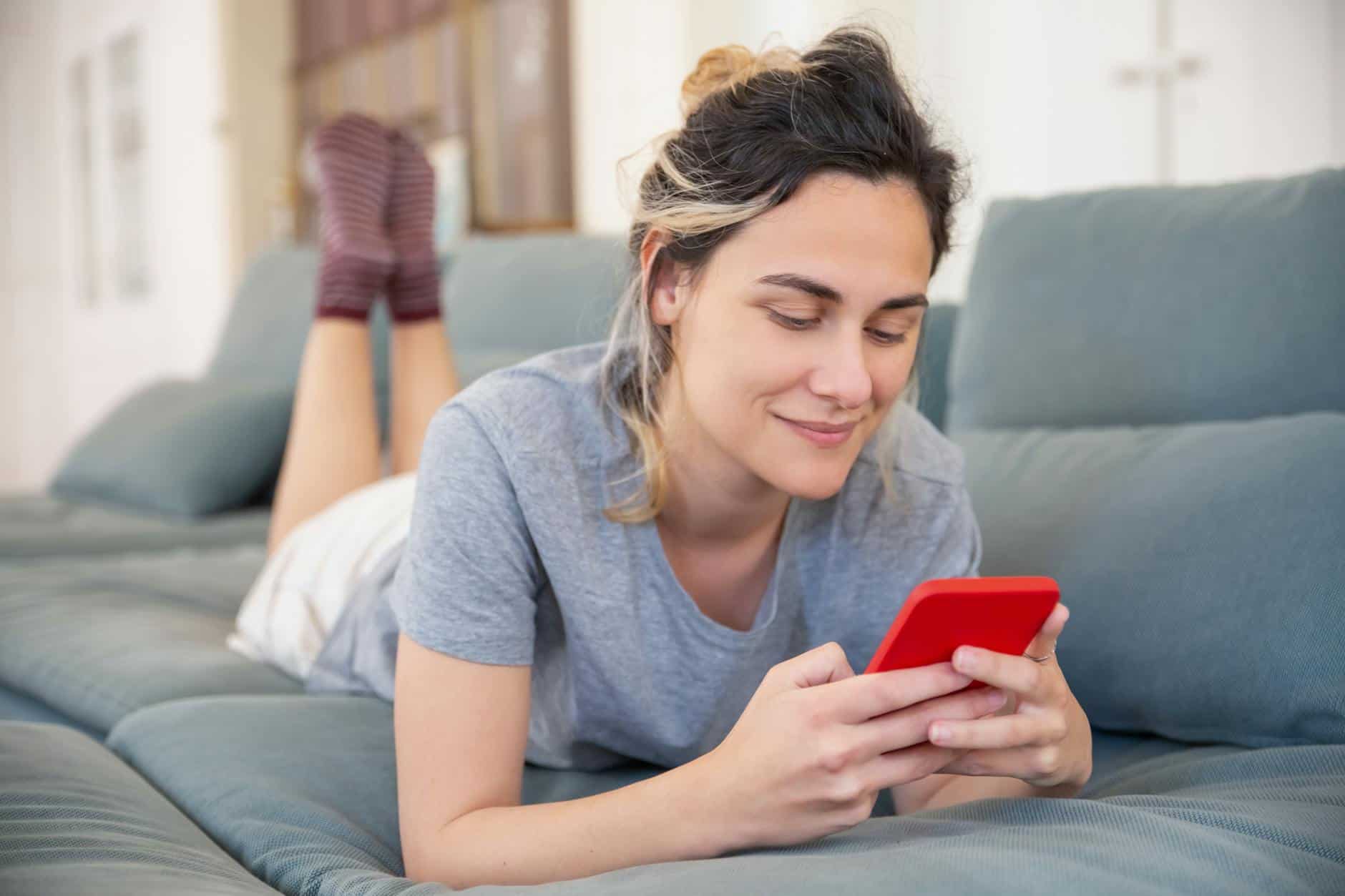 close up shot of a woman lying on sofa while using her cellphone for somatic prompts from chatgpt