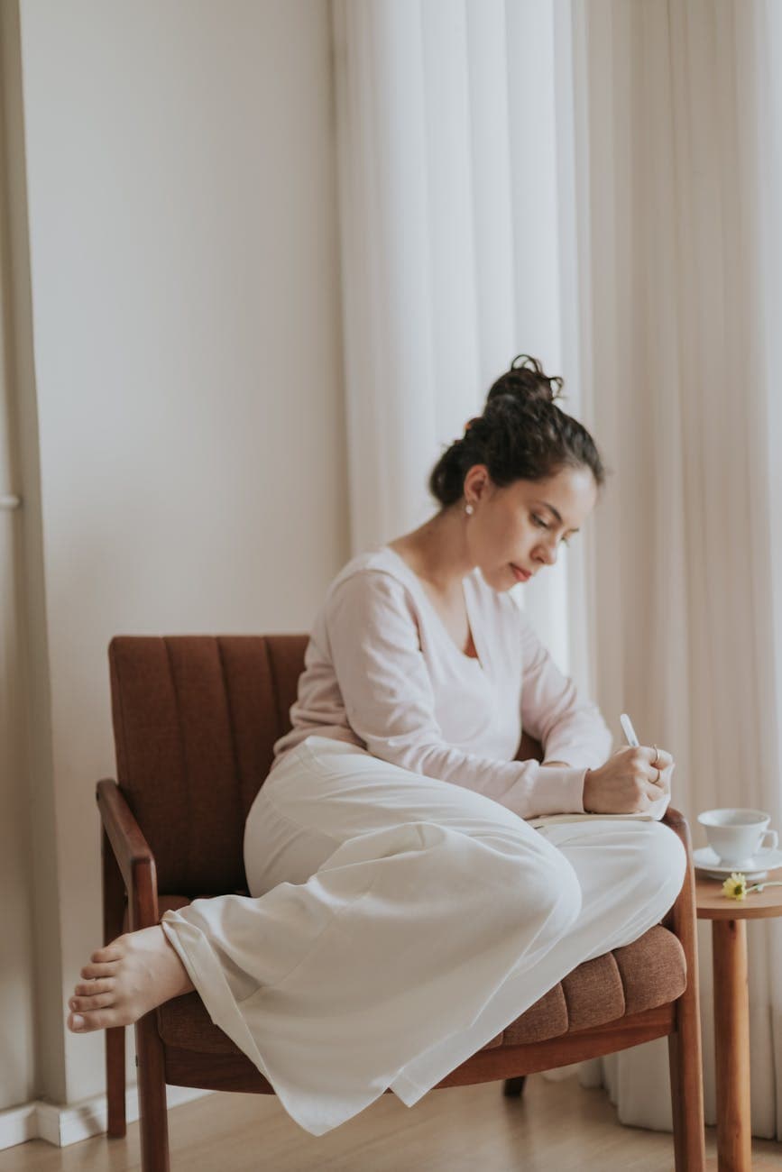 woman journaling in a cozy chair at home