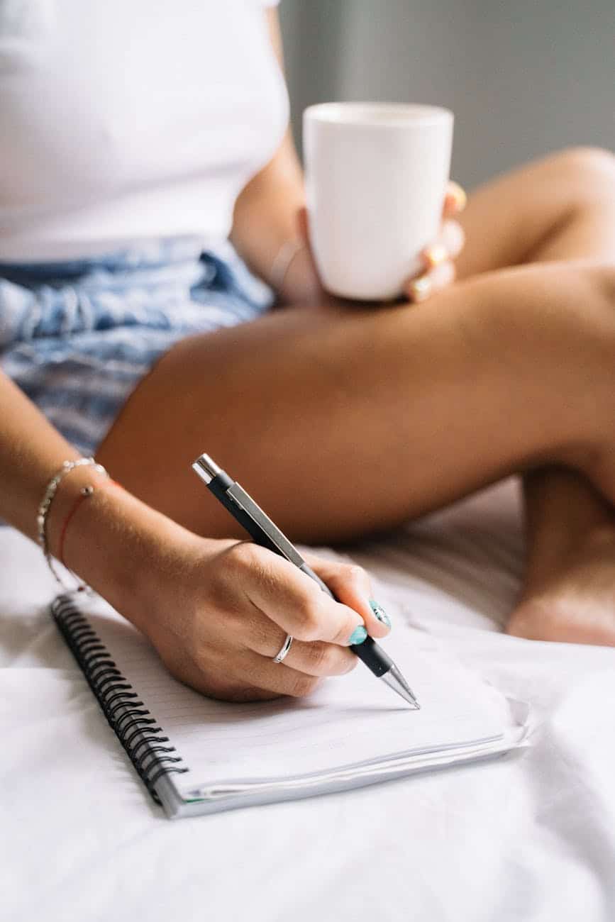 woman drinking coffee and writing a note