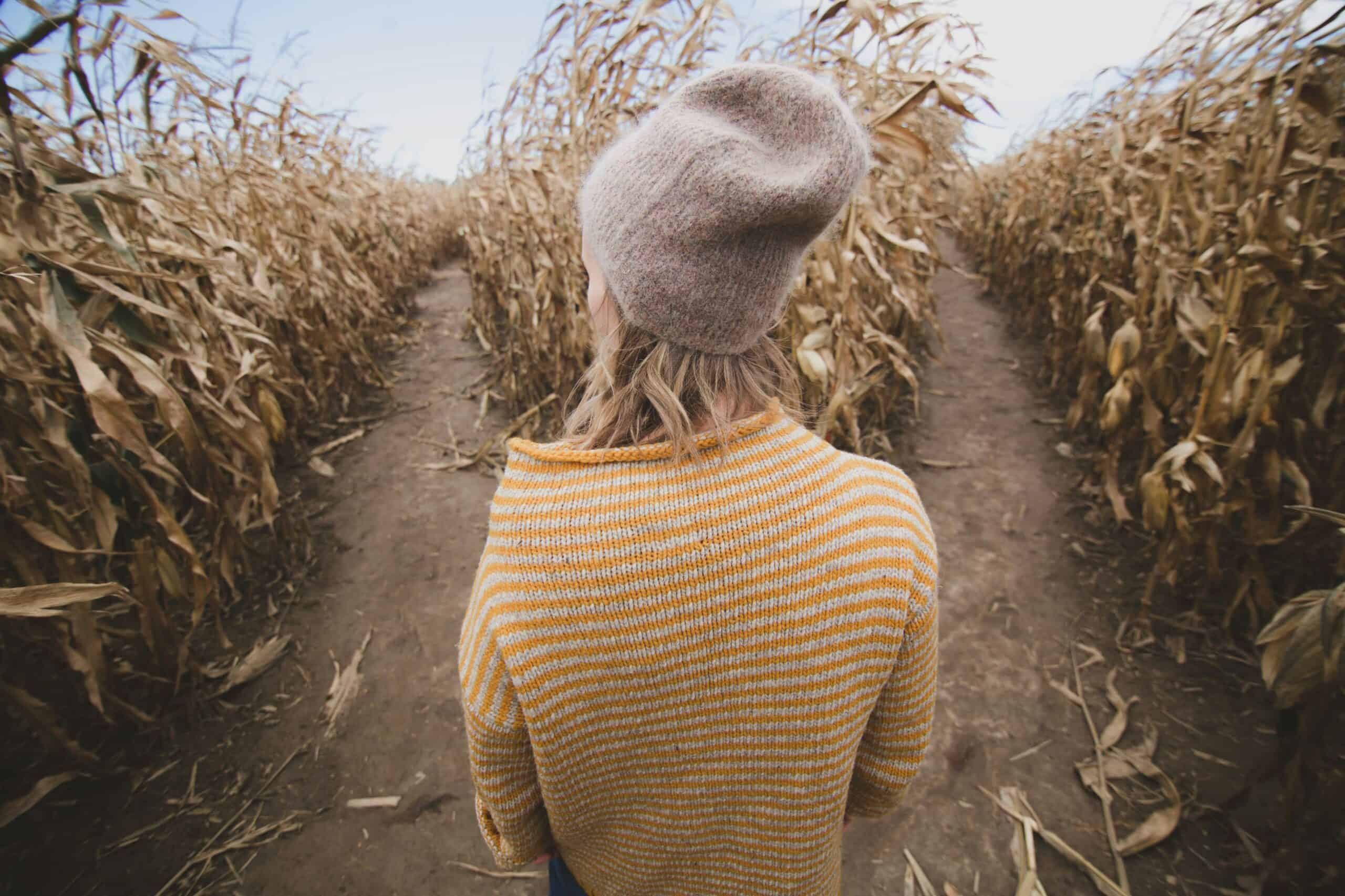 Woman walking through a cornfield, symbolizing decision-making and clarity.