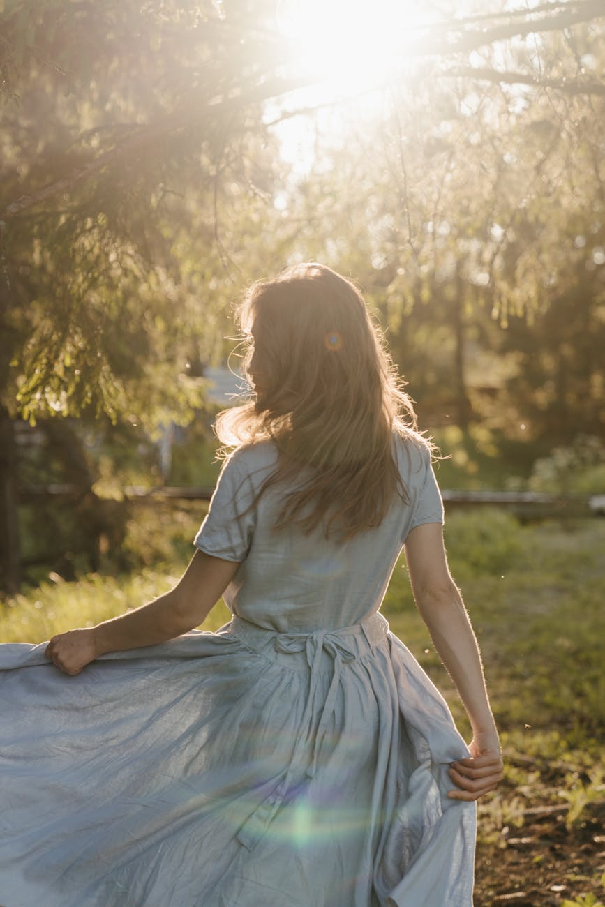 girl in white dress sitting on green grass