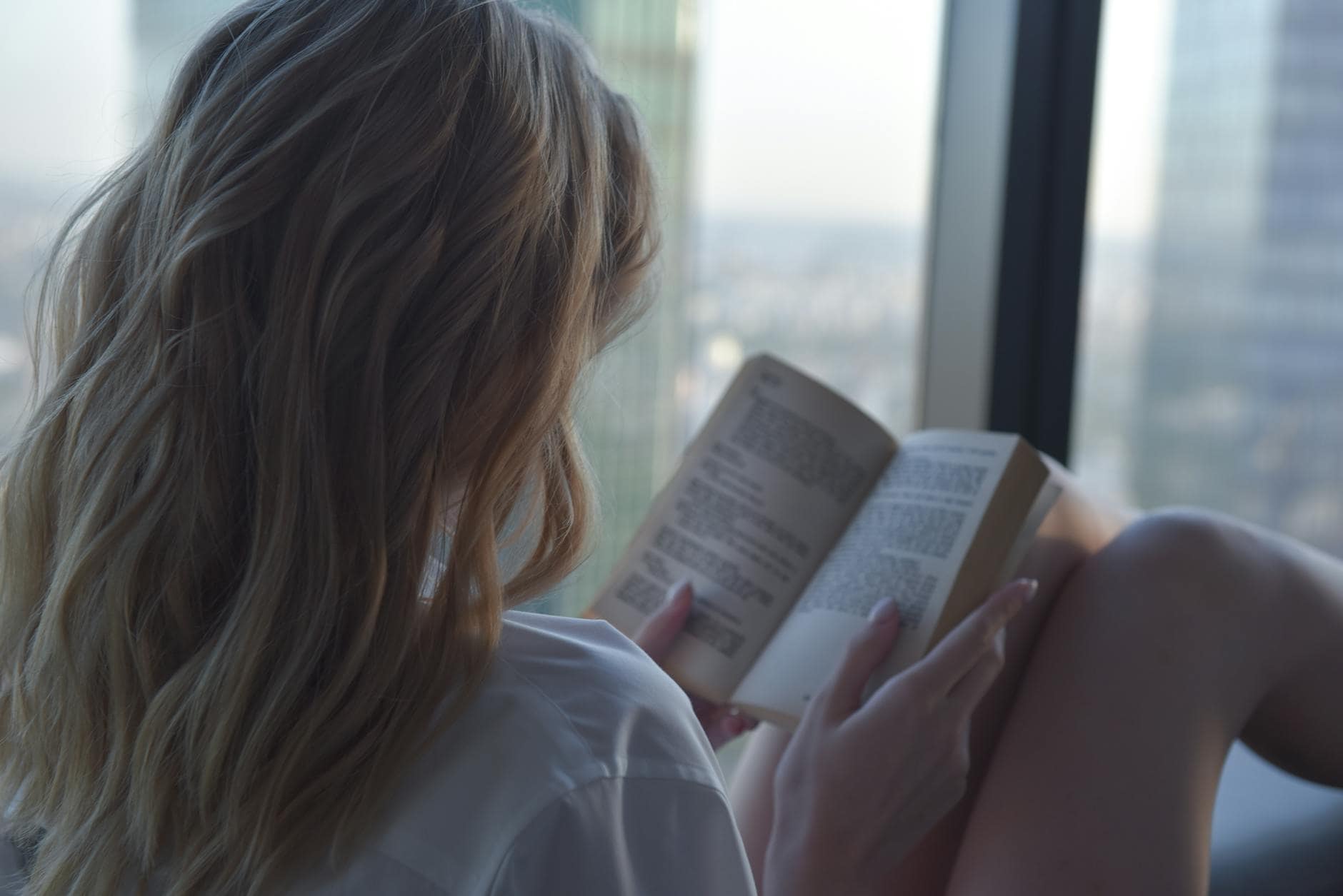 woman in white shirt reading book