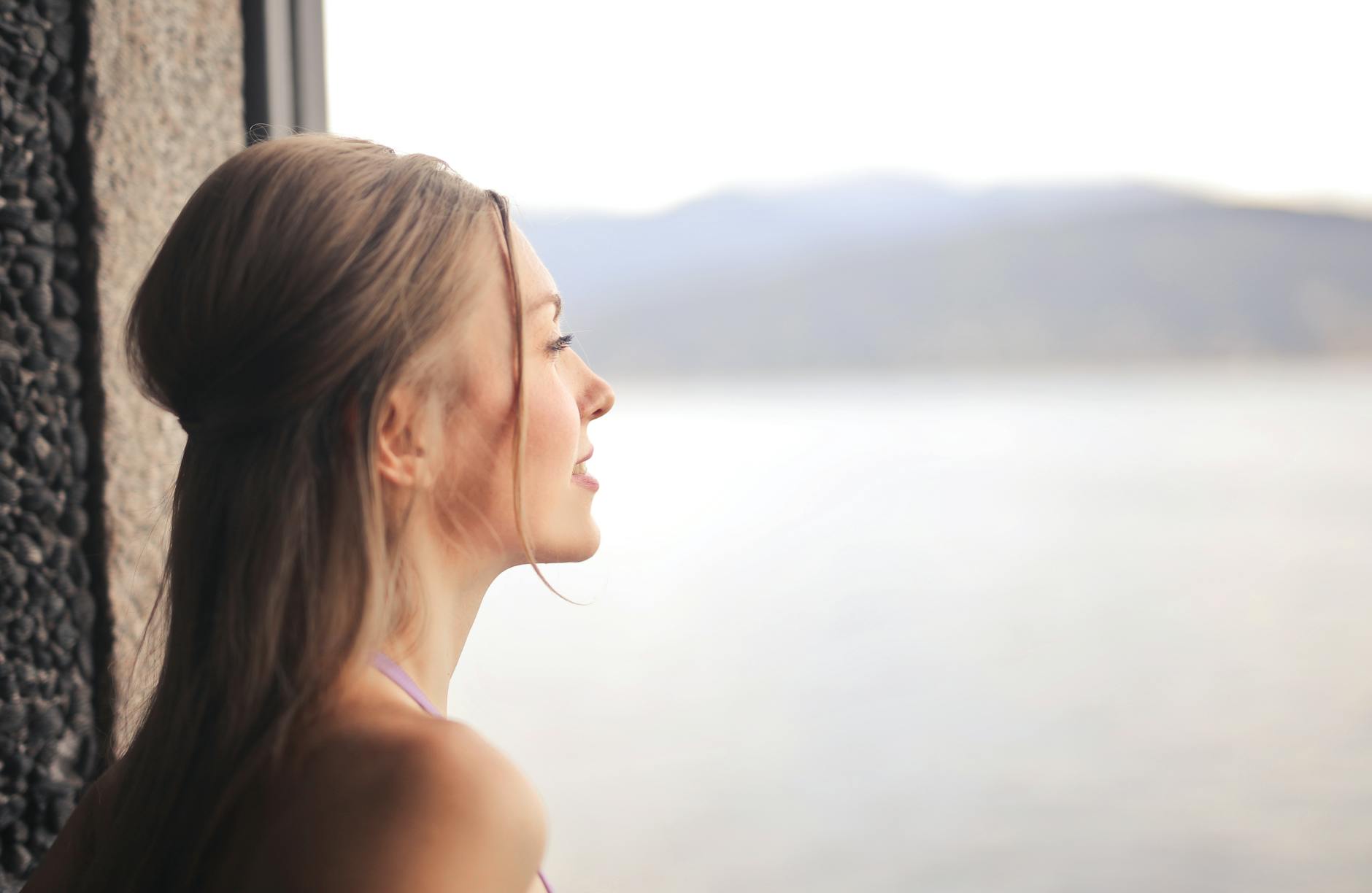 side profile of woman looking outside the window