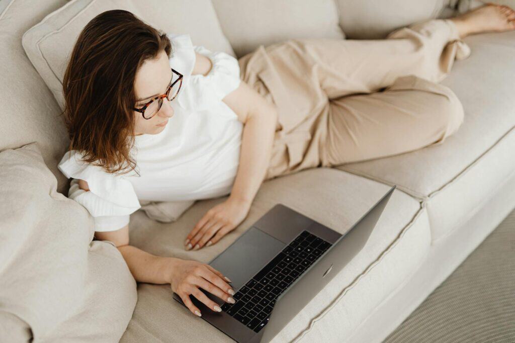 woman on couch experiencing functional freeze staring at laptop