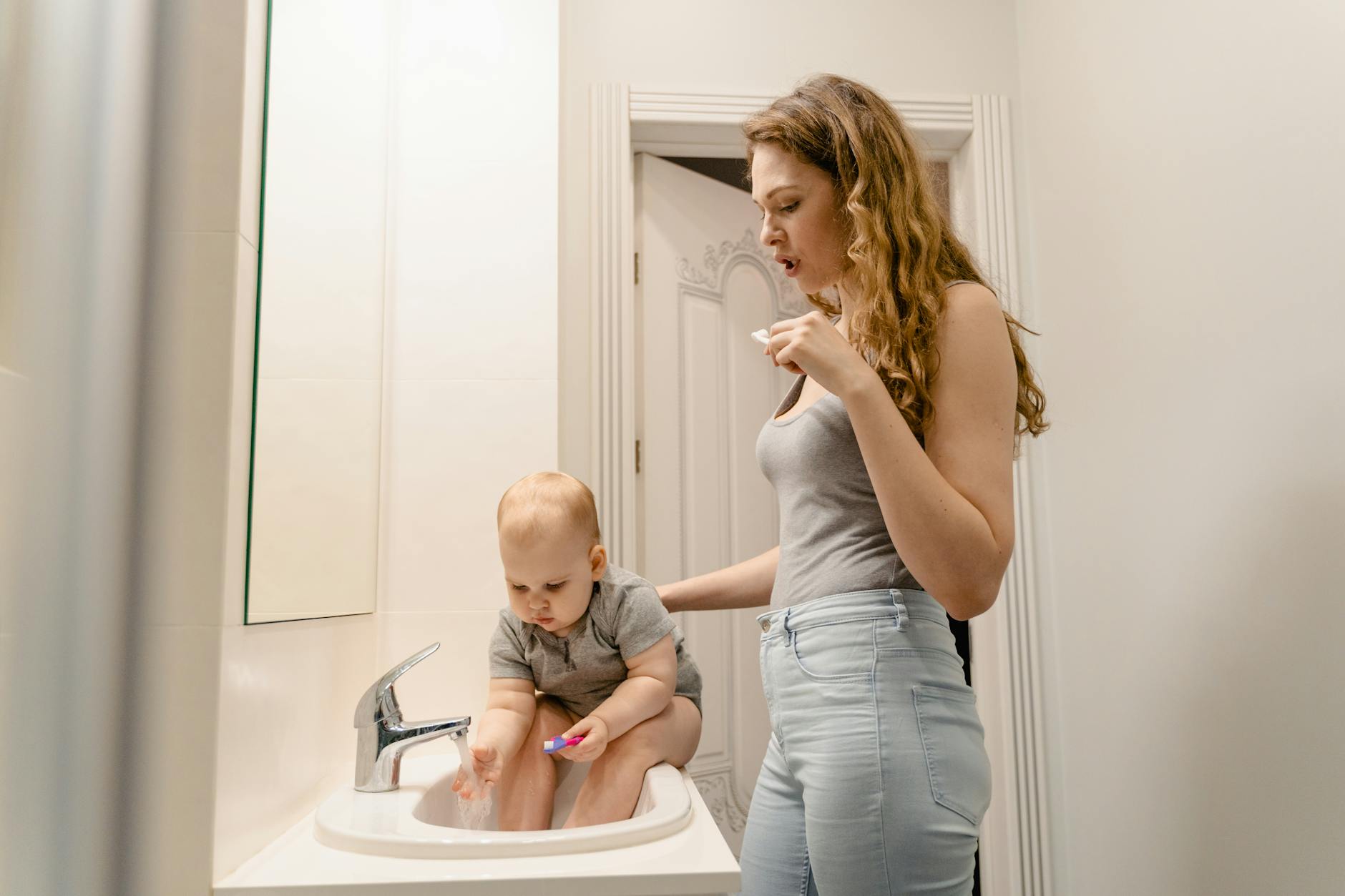 woman and her child brushing their teeth in the bathroom