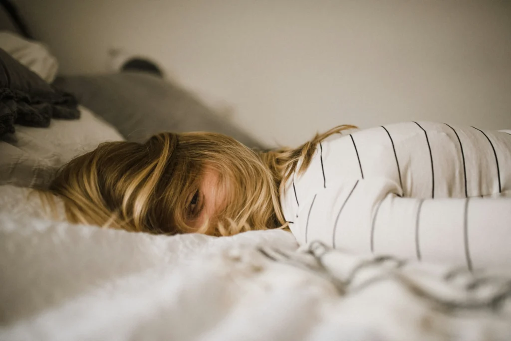 woman face down on her bed in full burnout mode looking for recovery