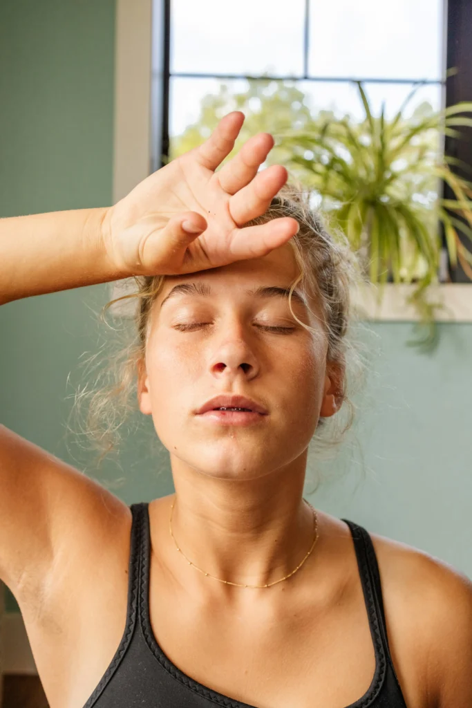 woman with hand on her head exhaling a deep Physiological Sigh