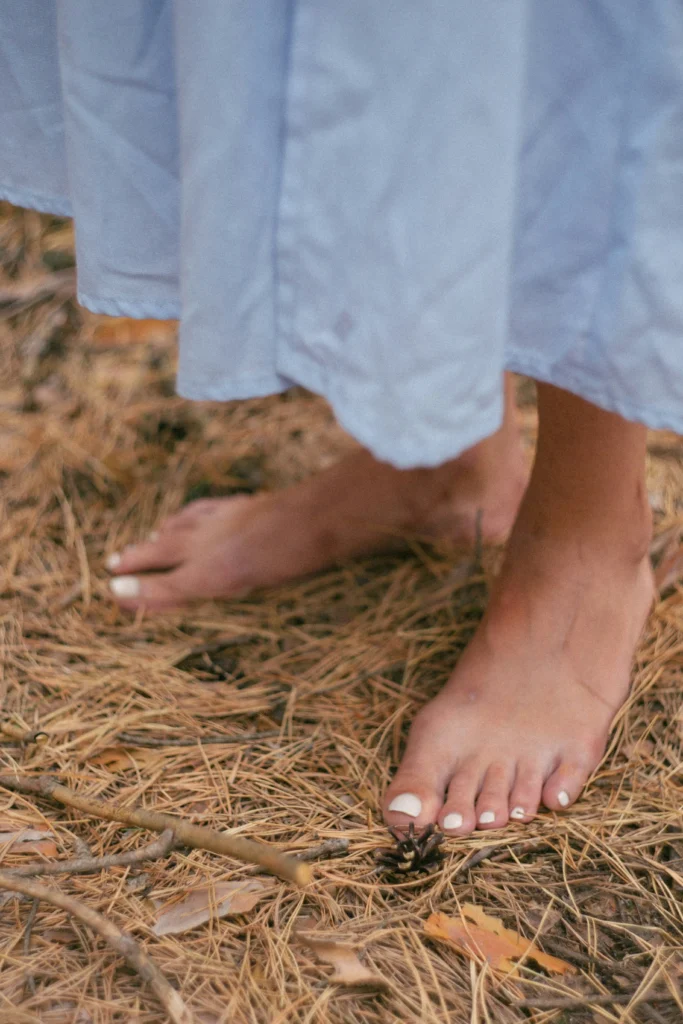 woman standing on the earth relaxing her toes to prevent burnout