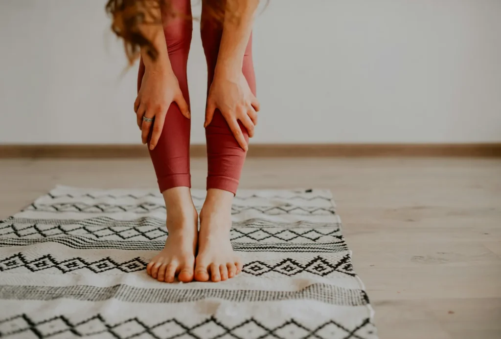 Bare feet on patterned rug forward fold