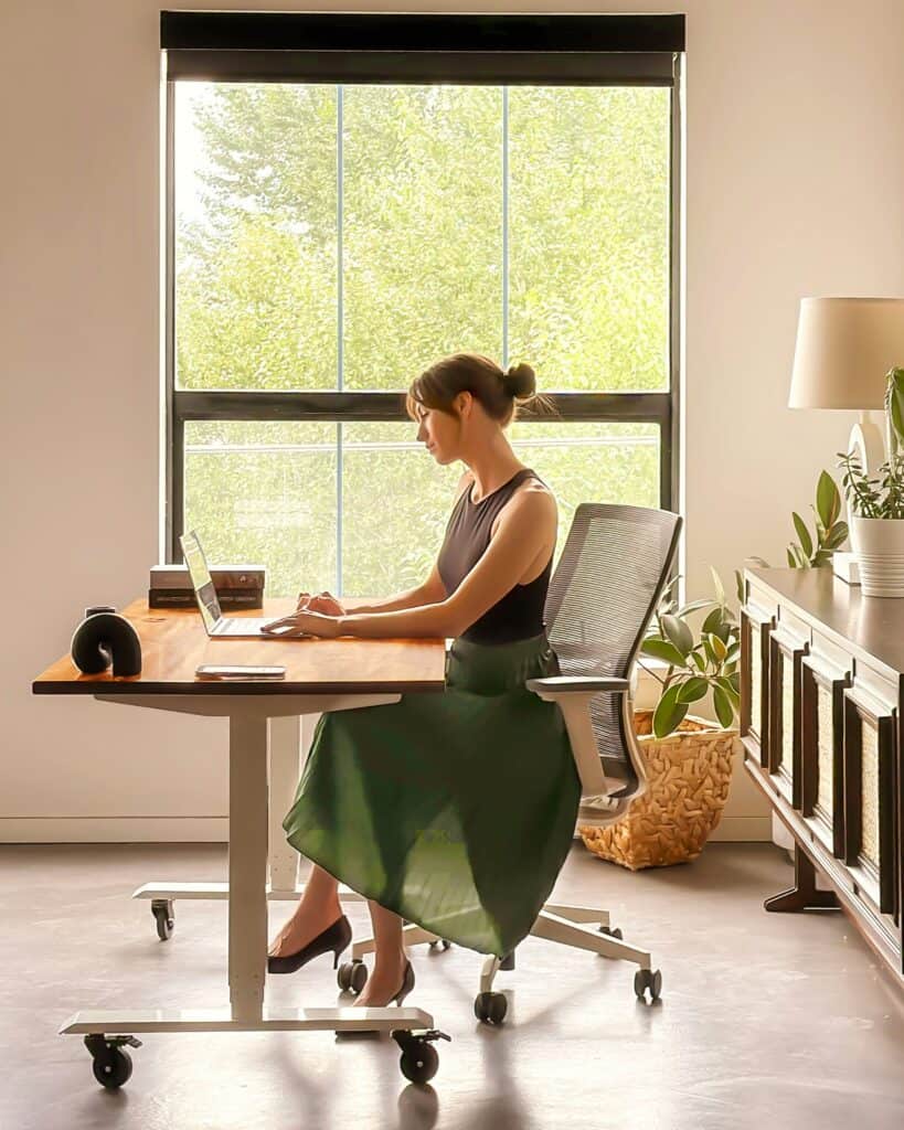 Woman practicing a body-based reset at her desk during work.