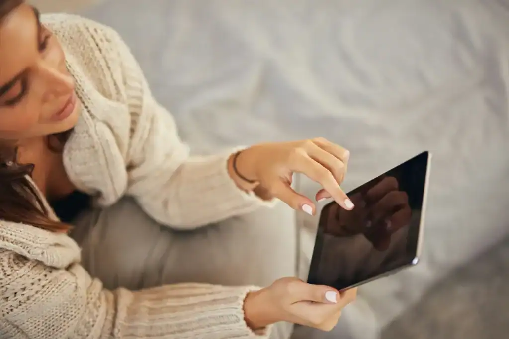 Overhead woman on tablet in chunky sweater