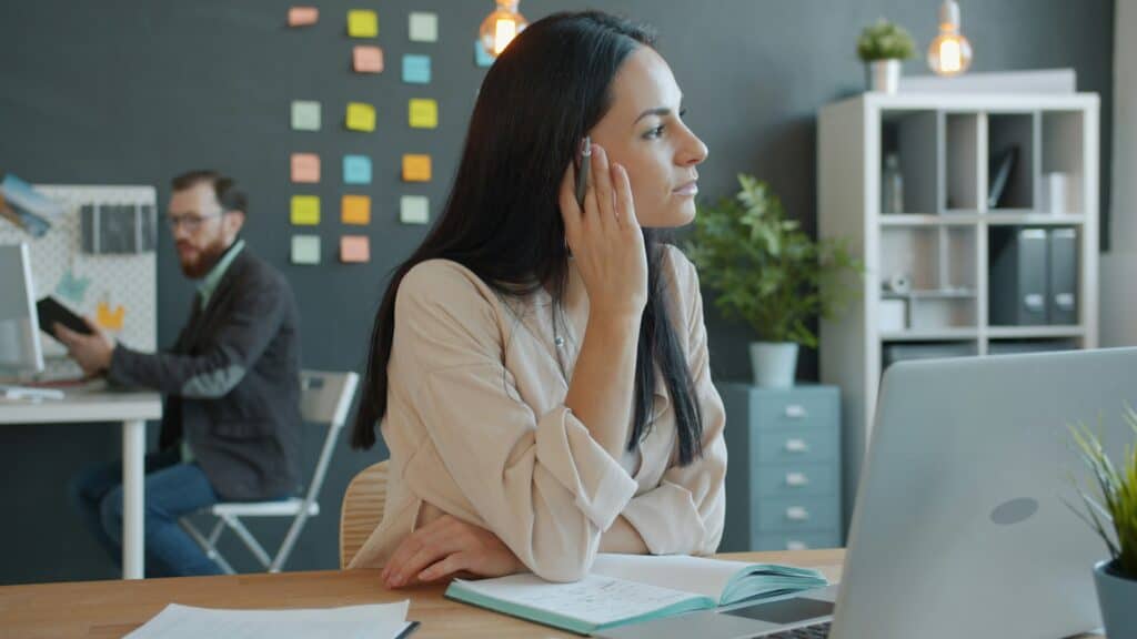Woman practicing a quick body-based reset at her desk to reduce burnout and increase focus.