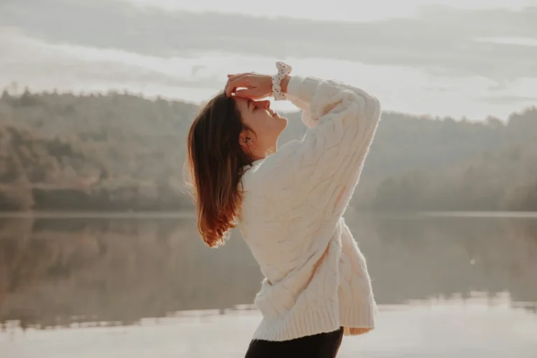 Woman cable knit sweater at misty lake sunrise