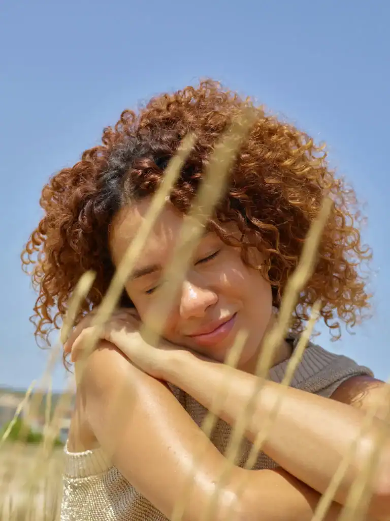 Woman curly hair resting head in field