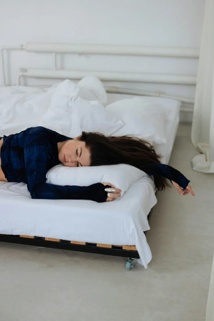 Woman lying flat on bed