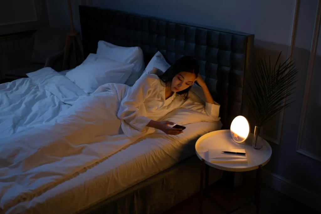 Woman on phone in bed before sleep