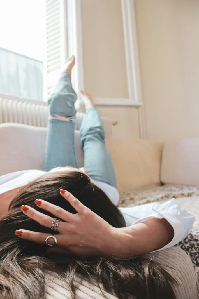 Woman with feet up on window orange nails